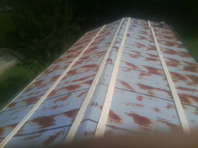 Rusted metal roof panels with new wood purlins before replacement — Storm Damage Roof Repair in Saint Johns by Roofing Brothers