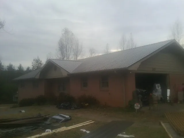 Gray metal roof on a stucco house with an attached garage in Saint Johns